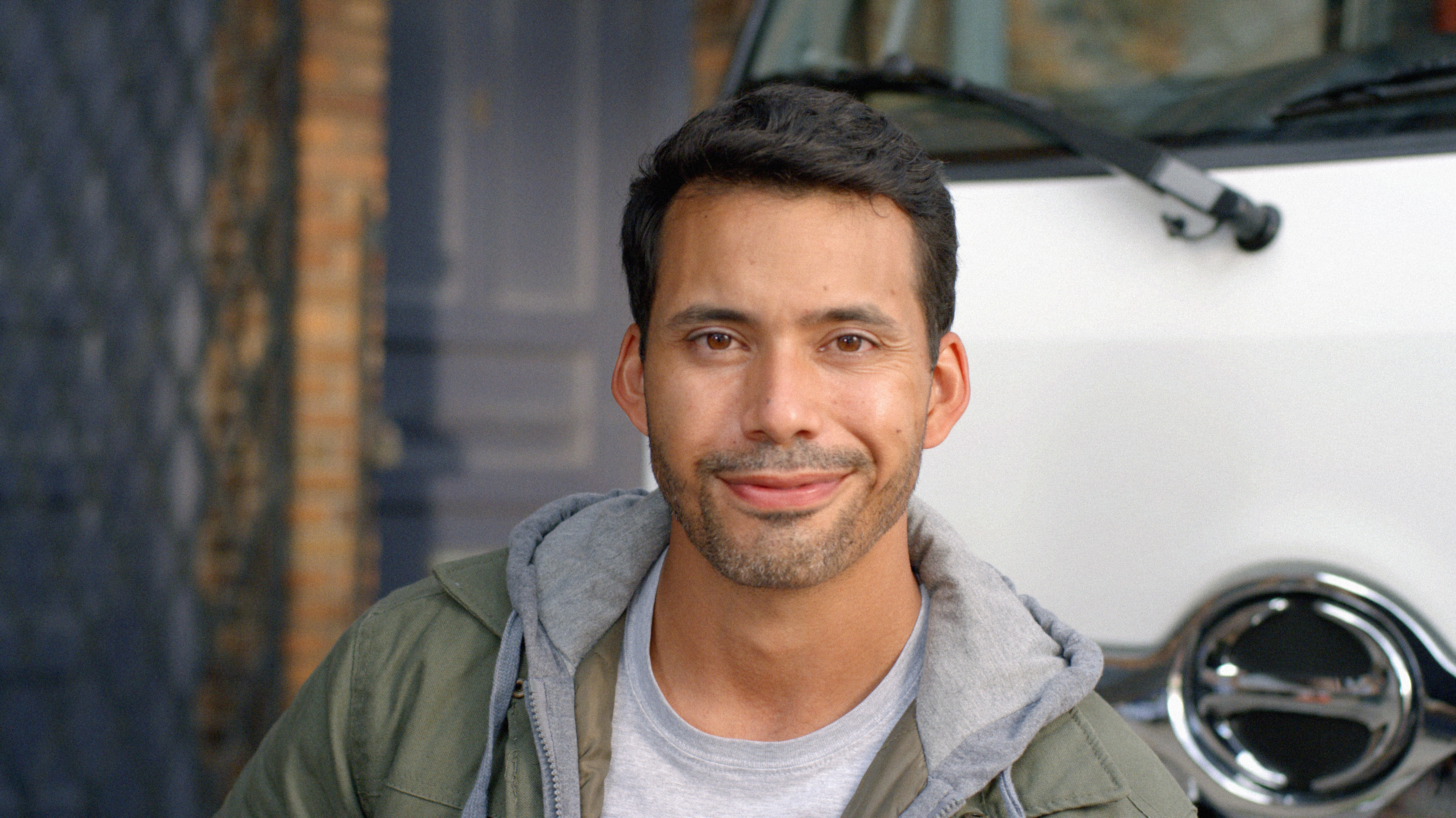 Man smiling in front of a Hino truck